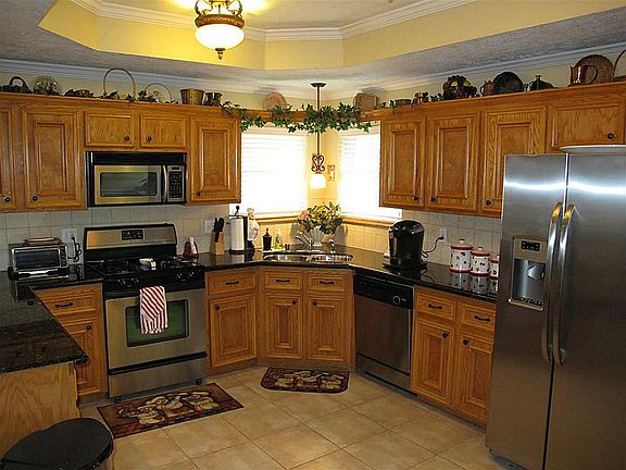 Gorgeous granite countertops, ceramic tile flooring, abundant cabinetry, dramatic trey ceiling, & large breakfast bar!