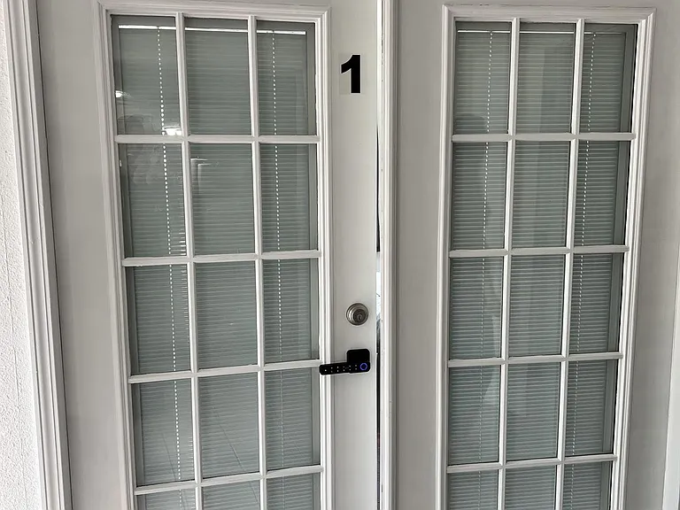 Secure double French-door entry with divided-light glass panels and interior blinds for privacy and natural light.
