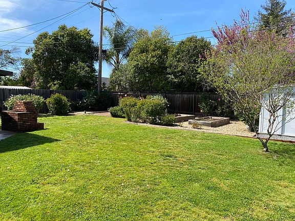 Large fenced back yard, with established roses, peonies and hydrangeas.