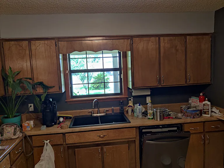 Kitchen as viewed from dinning room, has dual sink, dishwasher, stove, fridge, bar for additional eating area. Has tile floor and lots of cabinets for storage.