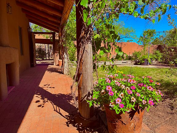 33' portal along south side of home, with private walled garden