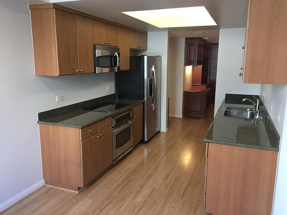 Galley kitchen with microwave oven, conventional electric over, dishwasher, refrigerator, and breakfast nook.