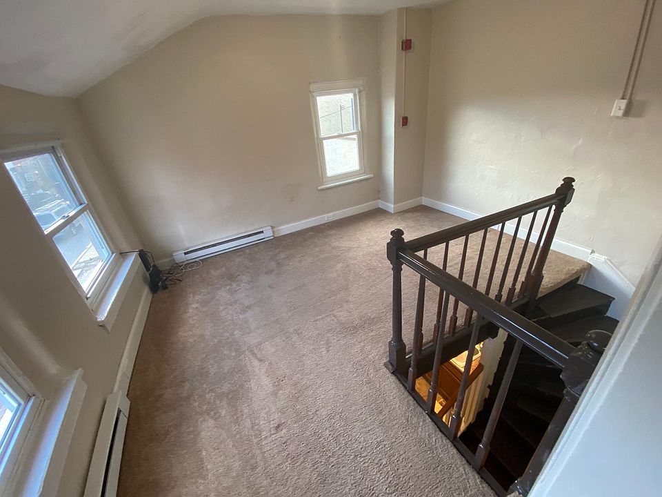 Living Room with lots of light coming in, unique staircase goes into first floor kitchen with walk out entrance to street
