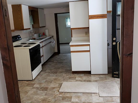 Taken from living room, picture of kitchen then entryway to bedroom. Bathroom is to the right, across from kitchen sink