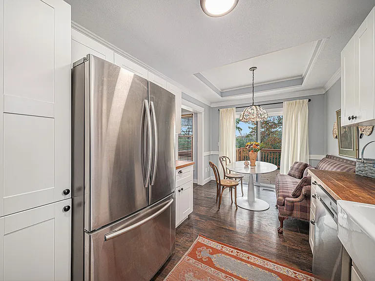 Airy layout connecting a fully equipped kitchen, inviting dining area, and sliding balcony doors that bring in sunlight and create a calm, welcoming atmosphere.