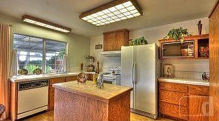 Bright kitchen with island, tile counter tops, hardwood floors