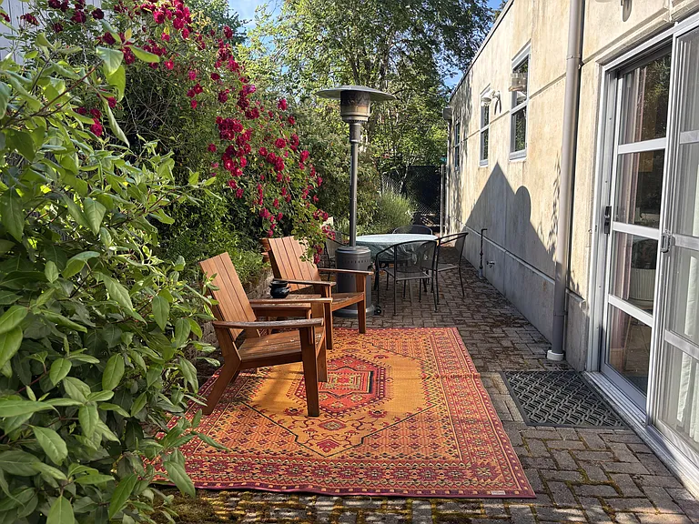 Back patio including pavers, raised brick garden beds, 3 separate sitting spaces surrounded by trees, shrubs, and flowers. Tons of privacy, shade, sun pockets, and plant heaven.