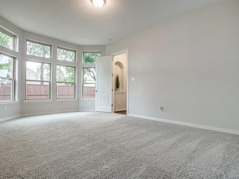 Spacious room featuring light gray carpet flooring and neutral wall paint
