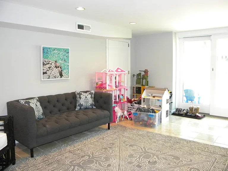Lower Level Play Room with Sliders that Lead to Fenced-in Backyard