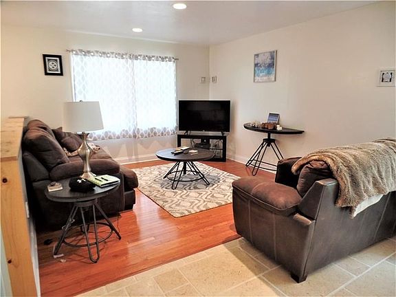 HARDWOOD FLOOR AND RECESSED LIGHTS IN THE LIVING ROOM.