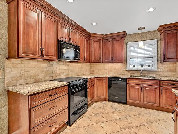 Crown Molding - Granite Counter tops, soft close drawers, upper and  lower corner Lazy Susans, 30" drawers to store your pots and pans, can lights, under cabinet lighting and travertine stone floor and backstop. Smooth top electric range with warming drawer, dishwasher and built in microwave.