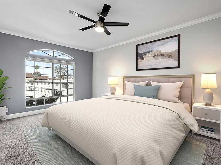 Carpeted bedroom featuring beautiful natural lighting and ceiling fan.
