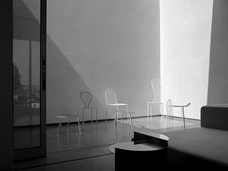 Artistic Lounge with Dramatic Light & Shadow Play _ A serene setting featuring sculptural furniture, oversized windows, and an interplay of natural light that enhances the architectural depth of Asteras Kings.