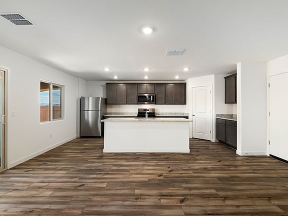The kitchen has granite countertops and designer wood cabinetry