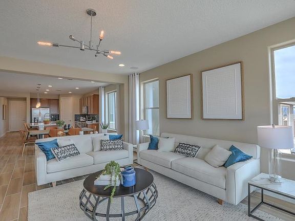 Spacious gathering room with ample room for seating and a sliding glass door to the backyard and cov