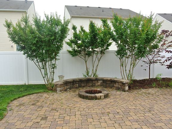 private backyard with fire pit and sitting wall