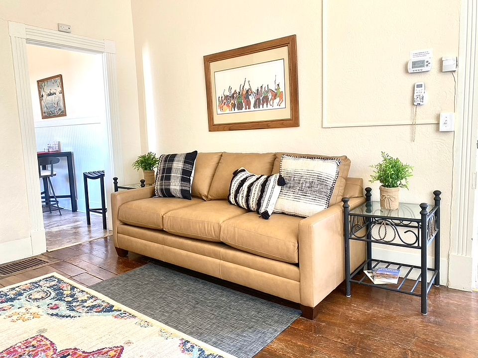 Sofa in Living Area with entry to kitchen on left. Sun filled Living Windows on the South and West which look out to the south.