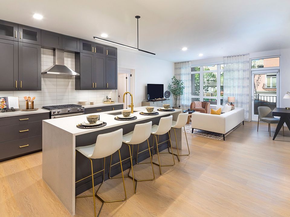 Marble-inspired quartz countertops with waterfall edge and backplash* combined with stainless steel appliances and gas ranges