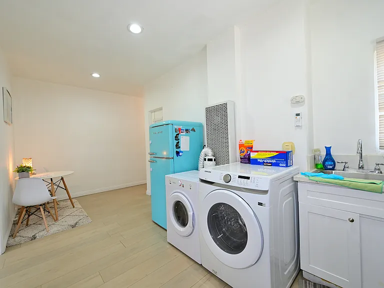 Fully furnished living room with upgraded kitchen, appliances, and laundry machines