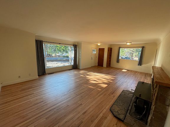 Expansive living room with hardwood floors and new picture windows.