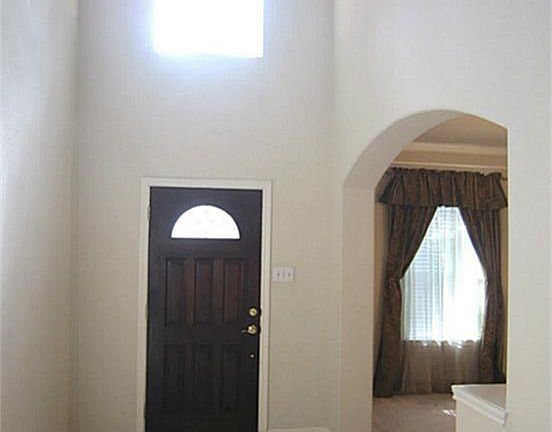 Bright two story entryway with formal entertaining space to left.