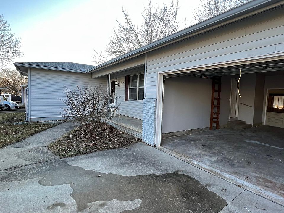 front of house with covered porch and oversized driveway