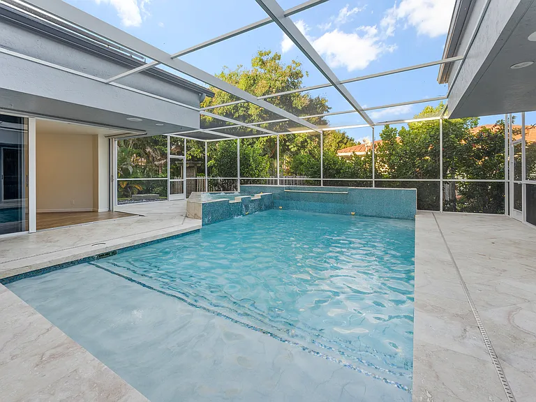 Screened pool and spa surrounded by the home