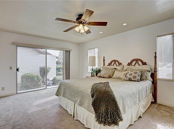 Expansive master bedrooms with a ceiling fan and a sliding glass door leading out to the side of the home.