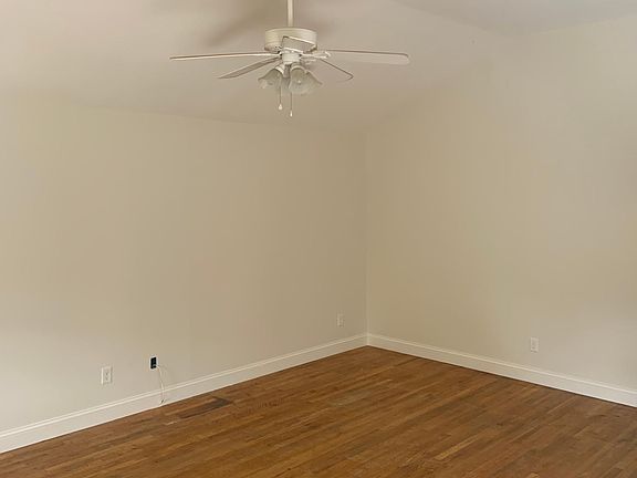 vaulted ceiling in main living room with ceiling fan