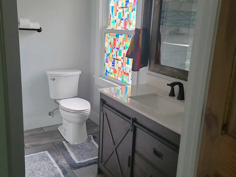 Master bathroom with new toilet, hand tiled shower, and tasteful vanity.