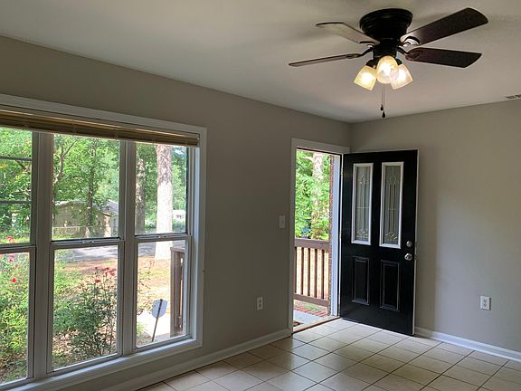 Front room with the front door open. Note that the property will be getting new windows throughout!