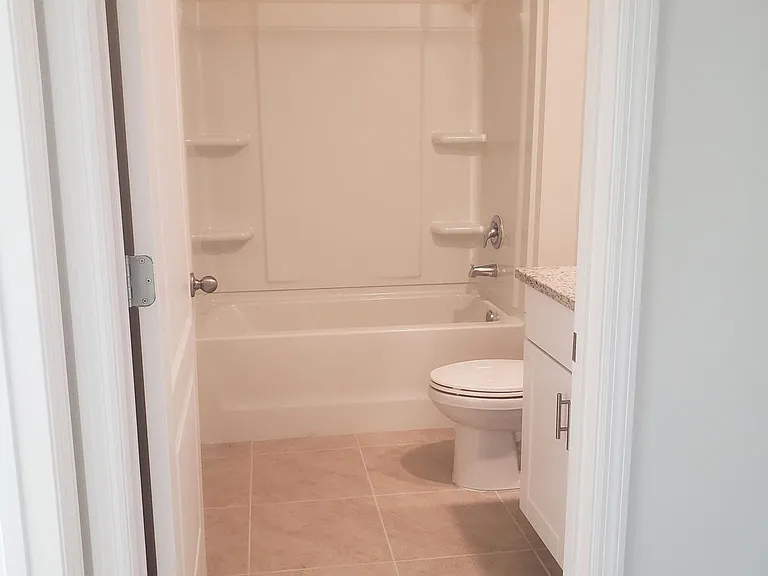 Guest/Family bathroom with granite vanity & tub/shower combo with curved shower rod which provides oversized bathing environment.