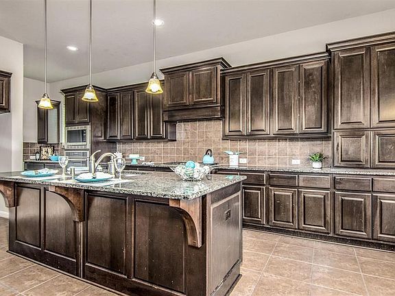 Beautiful kitchen with pendent lights and lots of cabinets.