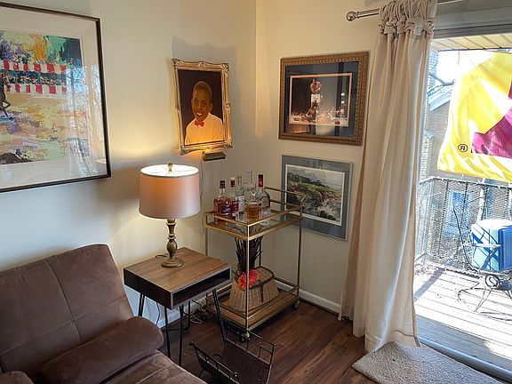 Couch with end tables and lamp with partial view of balcony.