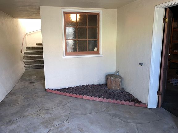 Private gated entry way with access door to garage