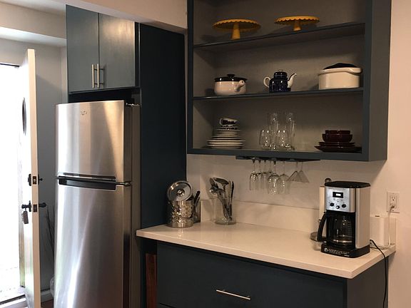 The private entrance leads to the kitchen with full refrigerator and bamboo floors throughout.