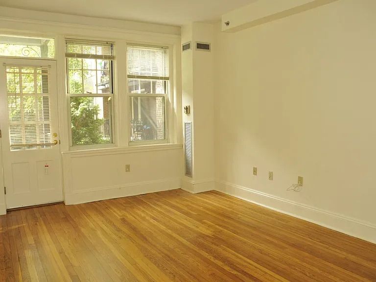 Room With Wooden Floors And Exit Door