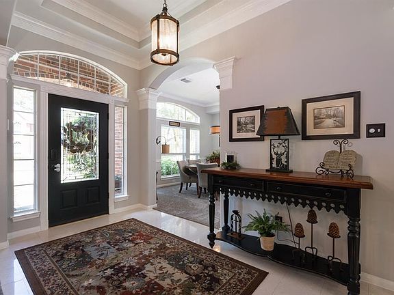 High tray ceiling and plenty of transoms creating a dramatic entry on marble flooring.