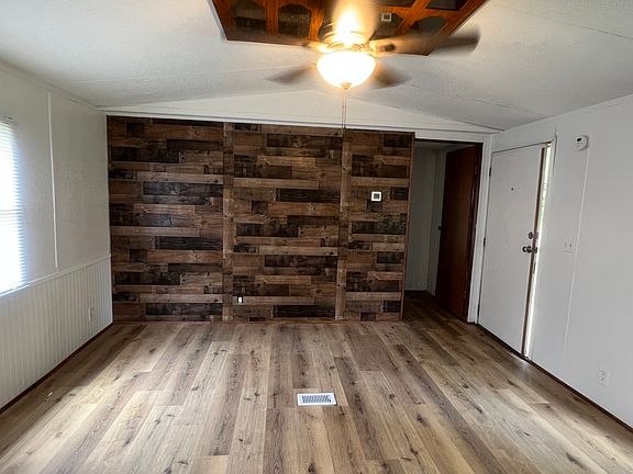 Living room with feature wall and ceiling fan.