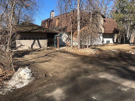 East view of house w/2-car garage, vine covered archway to front door.