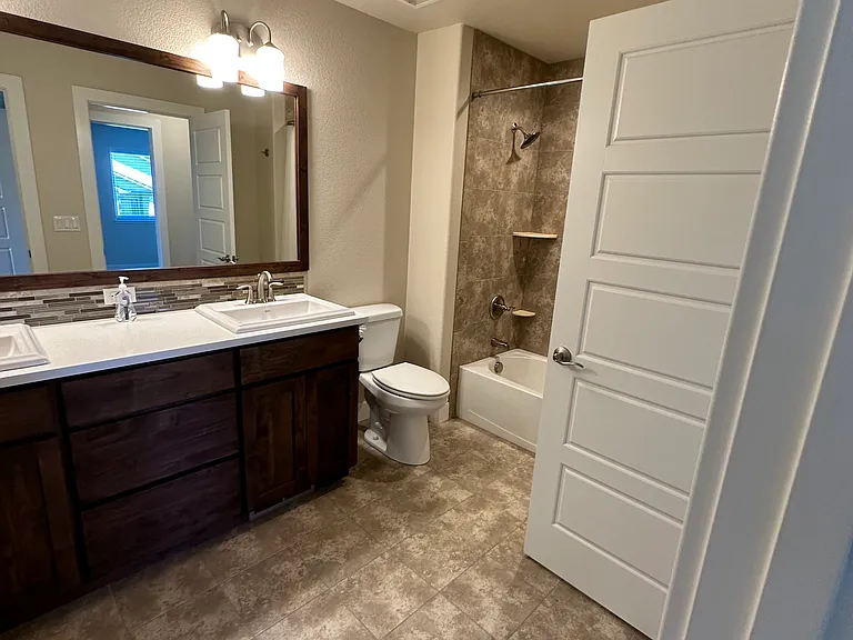 Shared upstairs bath with separate entrances. Dual sinks and shower with bathtub.