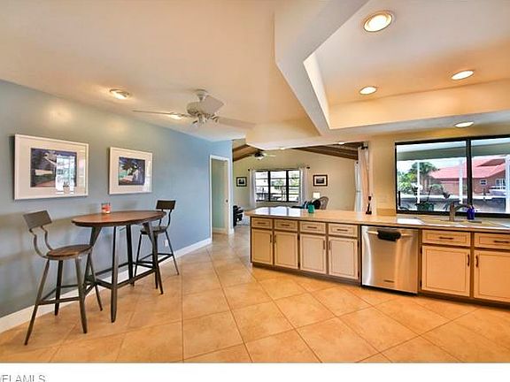 Kitchen dining area, large breakfast bar, pass through window to lanai and view toward family room.