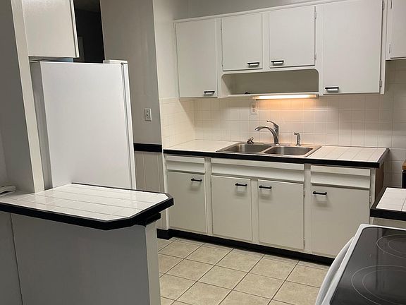 white/black kitchen with tile backsplash and peninsula