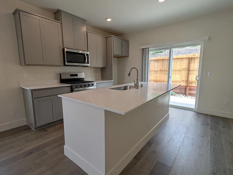 Sliding kitchen patio door to small landscapped backyard