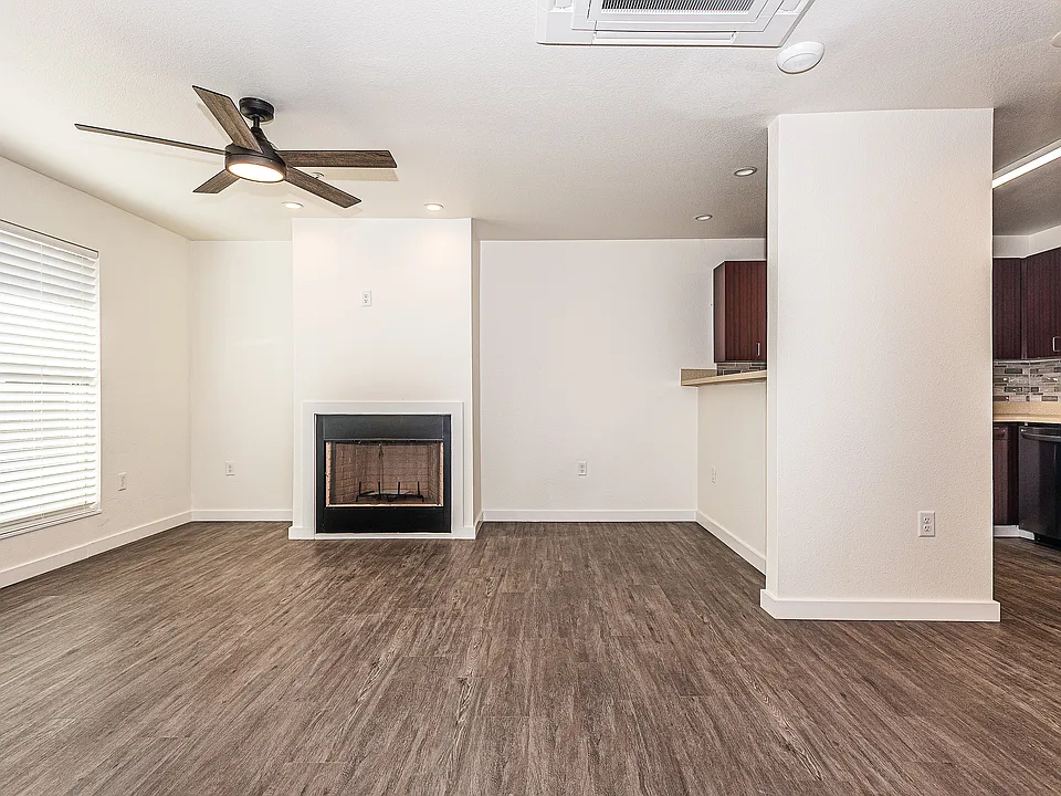 living room featuring luxury vinyl wood-style flooring, ceiling fan, and a healthy amount of sunlight