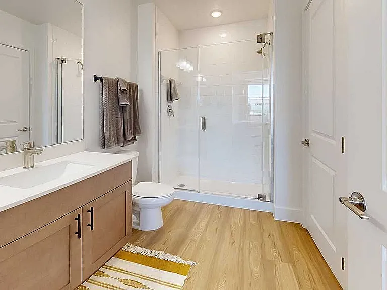 Step into elegance with this stylishly designed bathroom featuring a spacious glass shower.