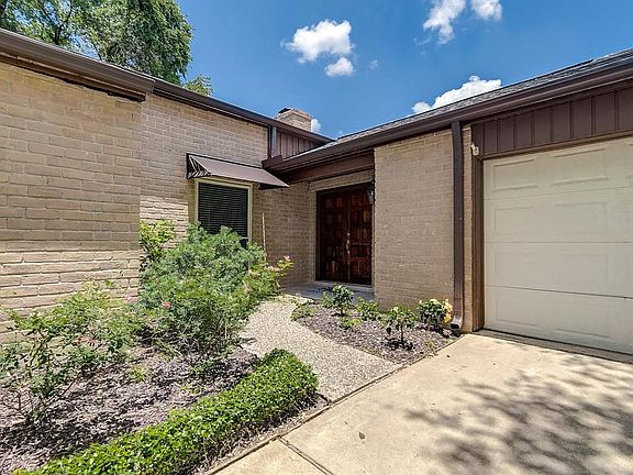 Roses and hibiscus surround the front door