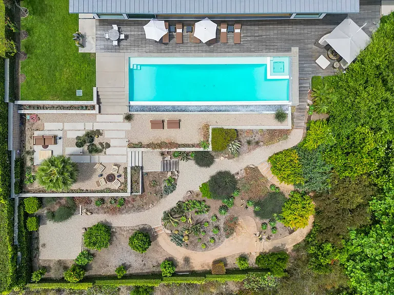 The expansive pool area features a sophisticated deck and luxurious amenities.
