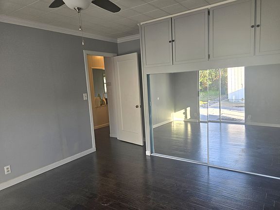 Master bedroom with sliding glass entry to back yard and deck. Mirrored closets. Lots of storage above.