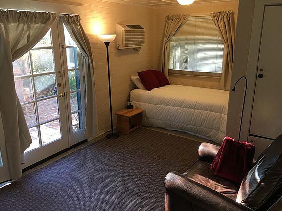 The second room has a twin-sized bed, an easy chair, and a work area.